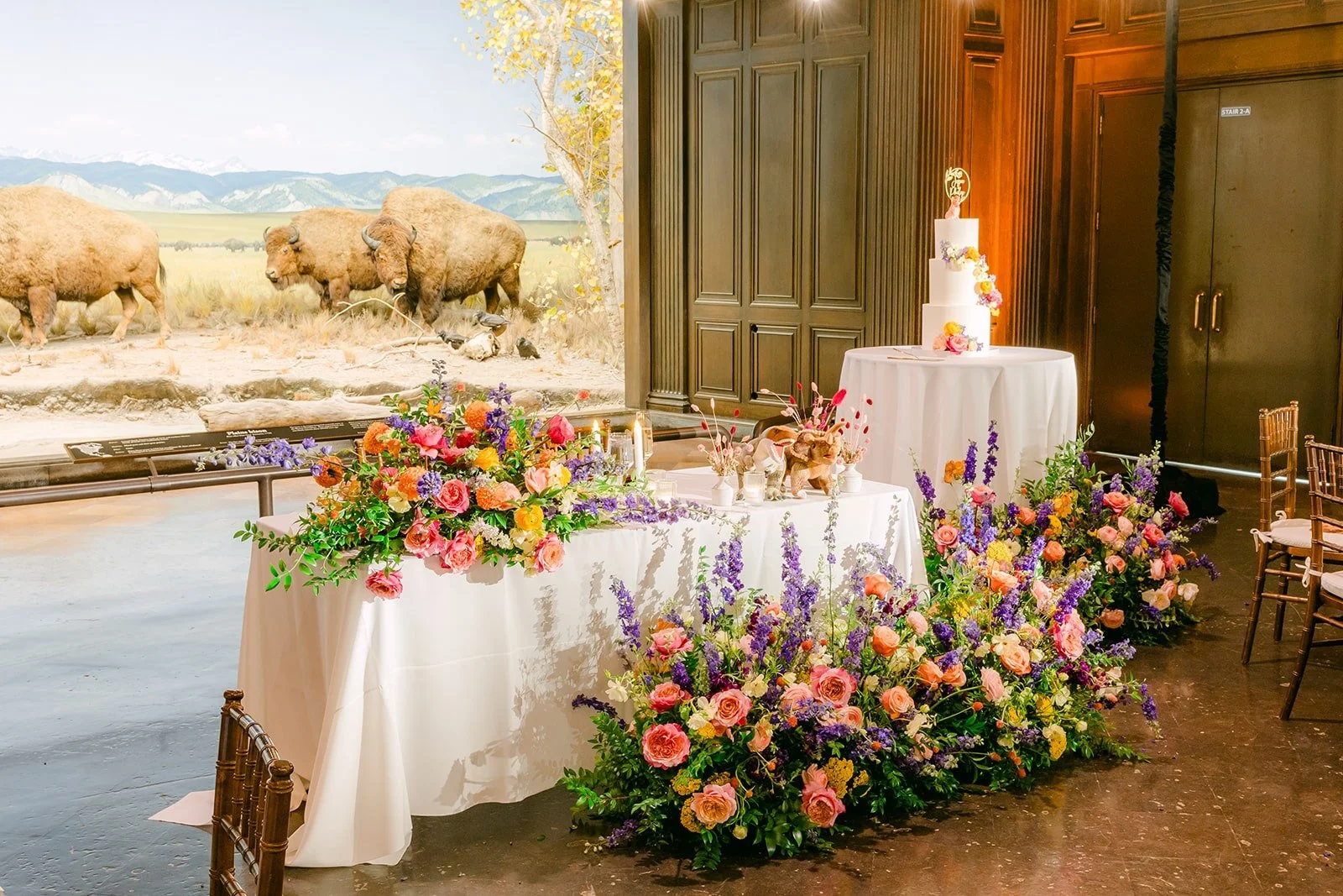 The head table with florals in front of the bison diorama