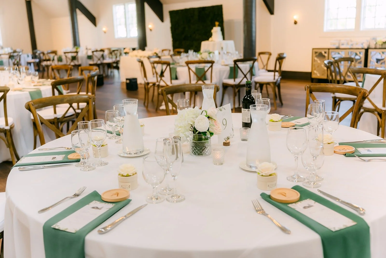 Round tables with sage green runners in the ballroom