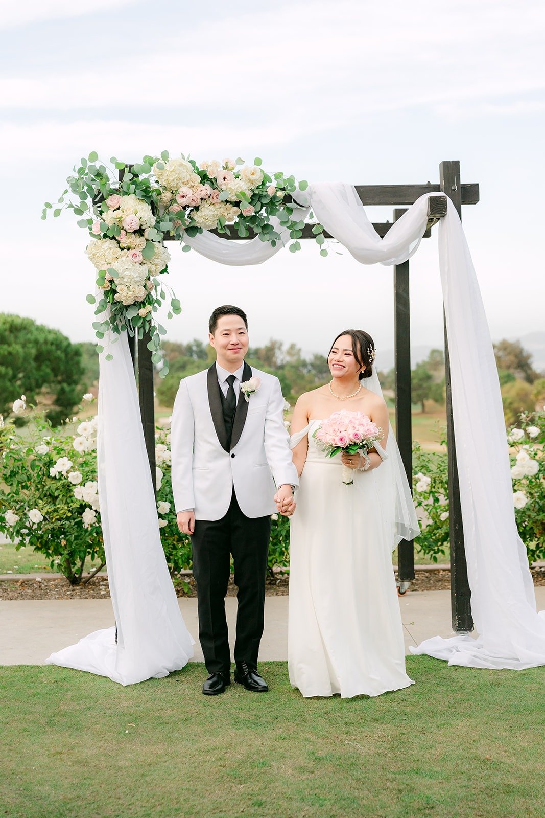 Ivy and Chungman just married under the arch, photographed by One and Only Production
