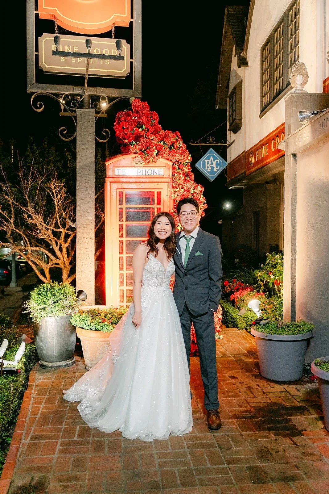 Valerie and Jason standing together outside the restaurant at night, photographed by One and Only Production