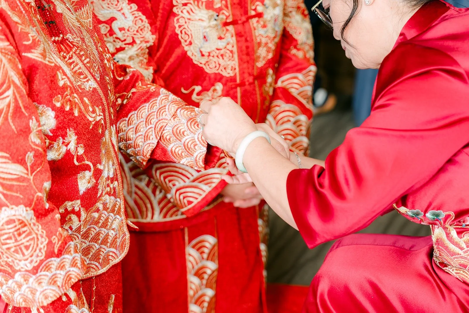 A family member fastens a gold bangle on Sochi's wrist