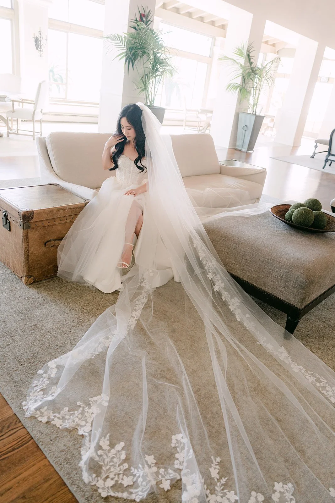 Bride lounging in the bridal suite with her cathedral veil spread out