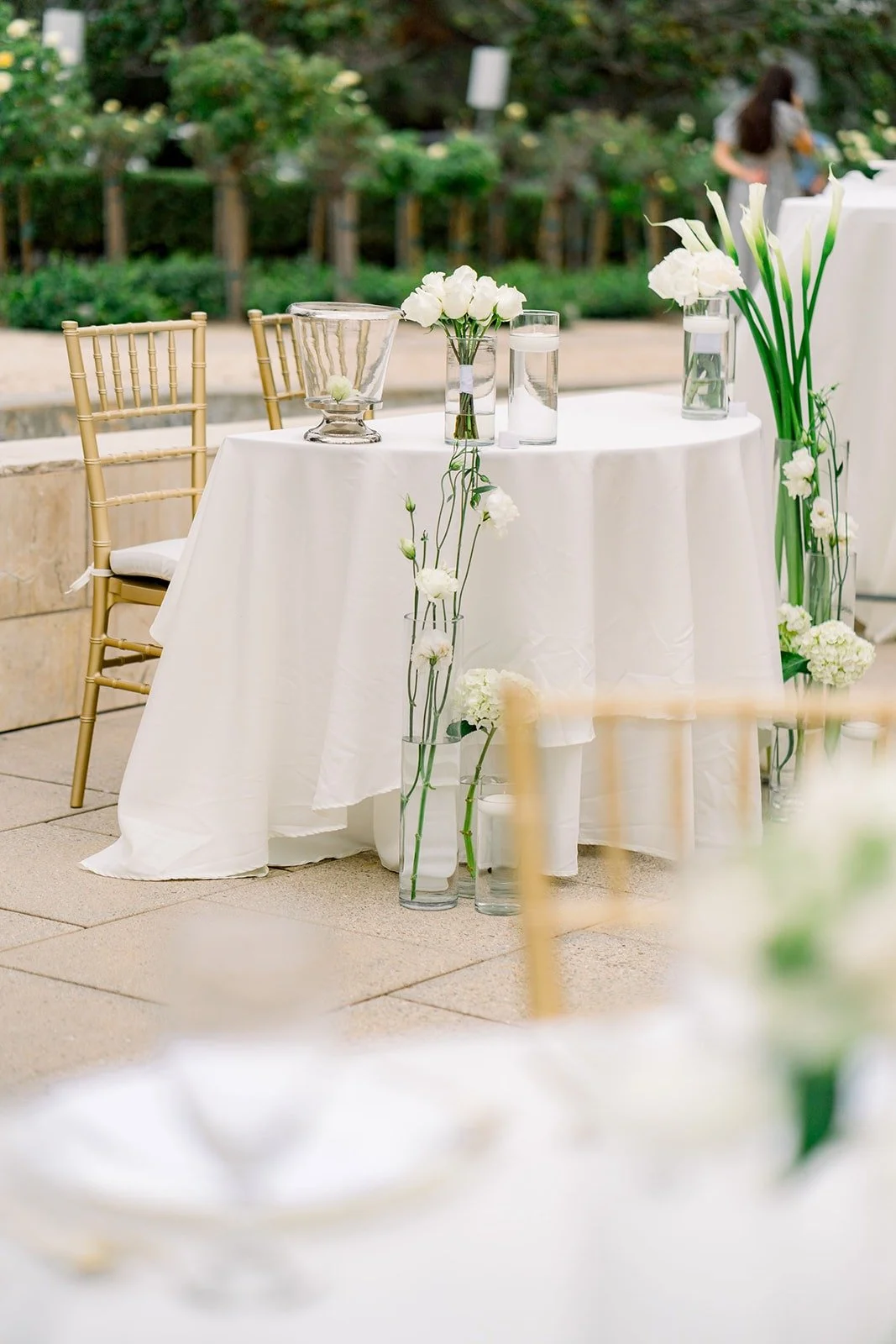 Tall white orchid centerpieces on the patio tables