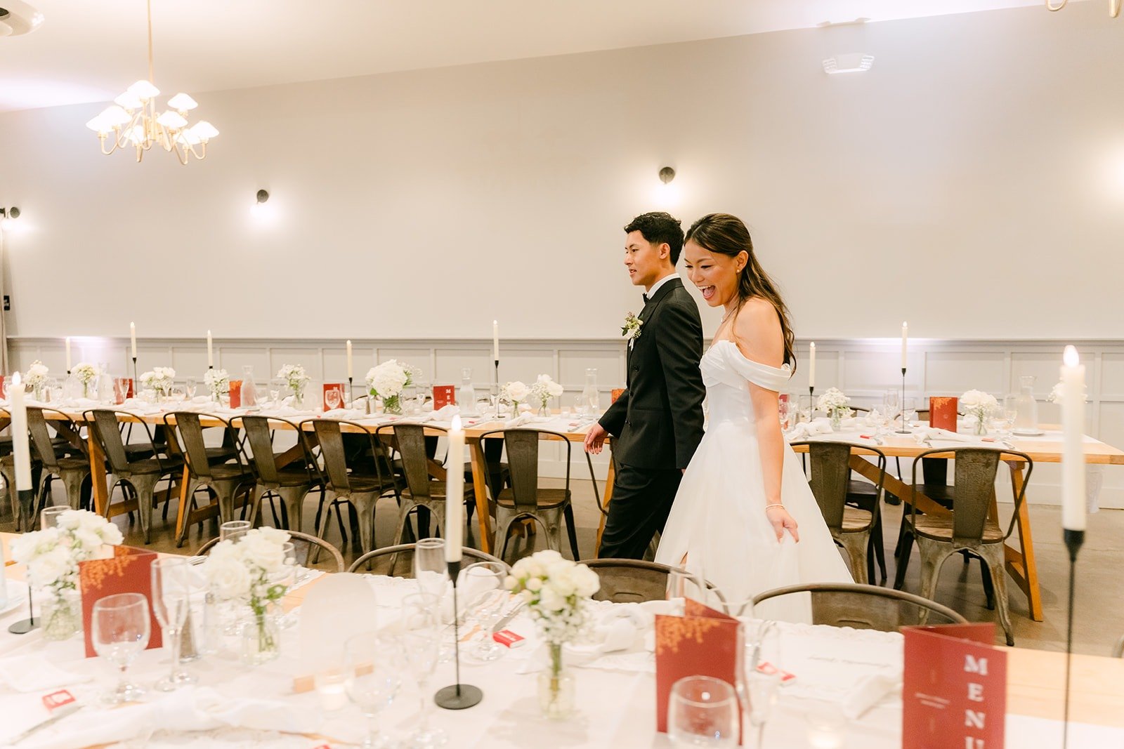 Jadee and Richard walking between the reception tables
