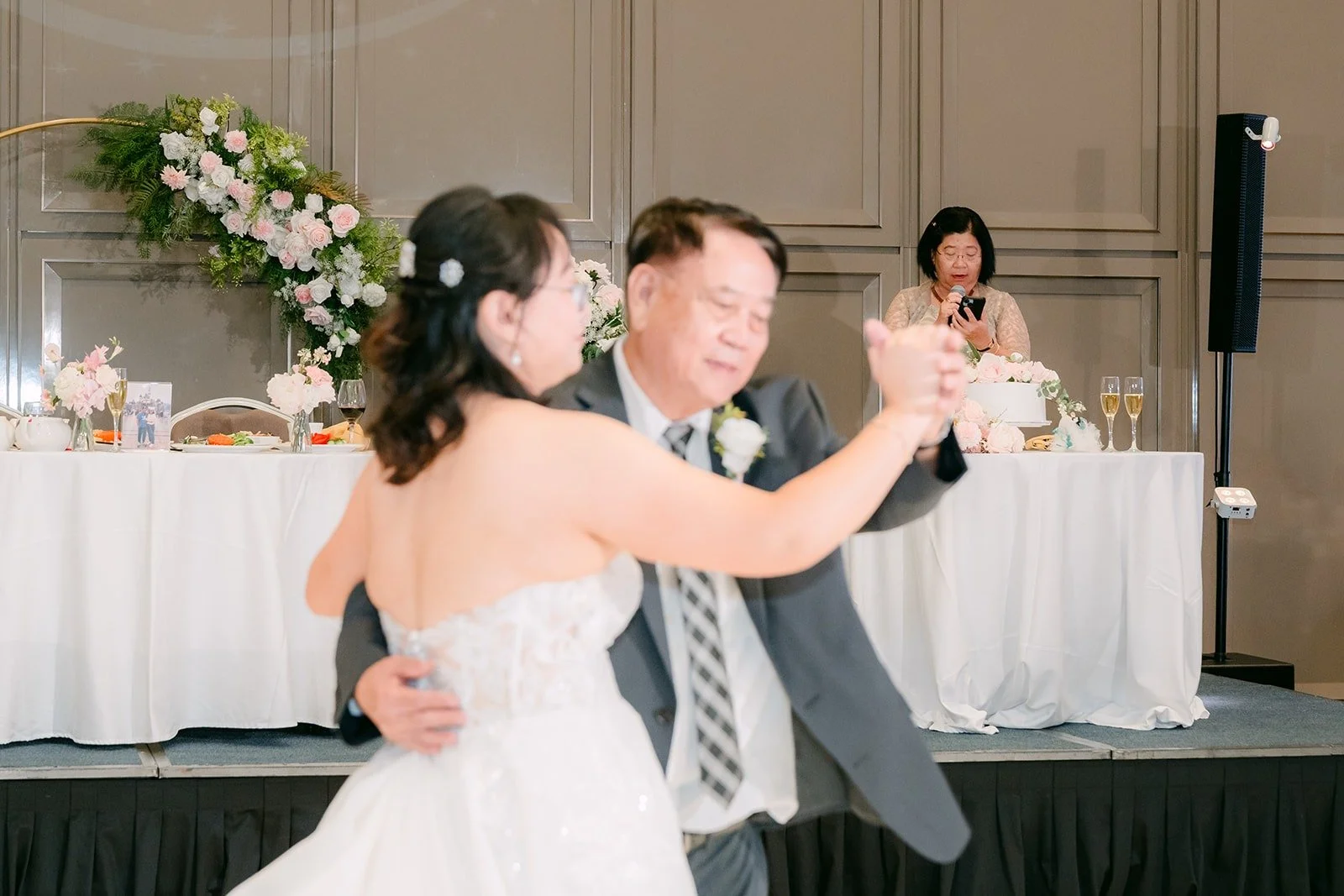 Stella smiling over her dance partner's shoulder during the parent dances