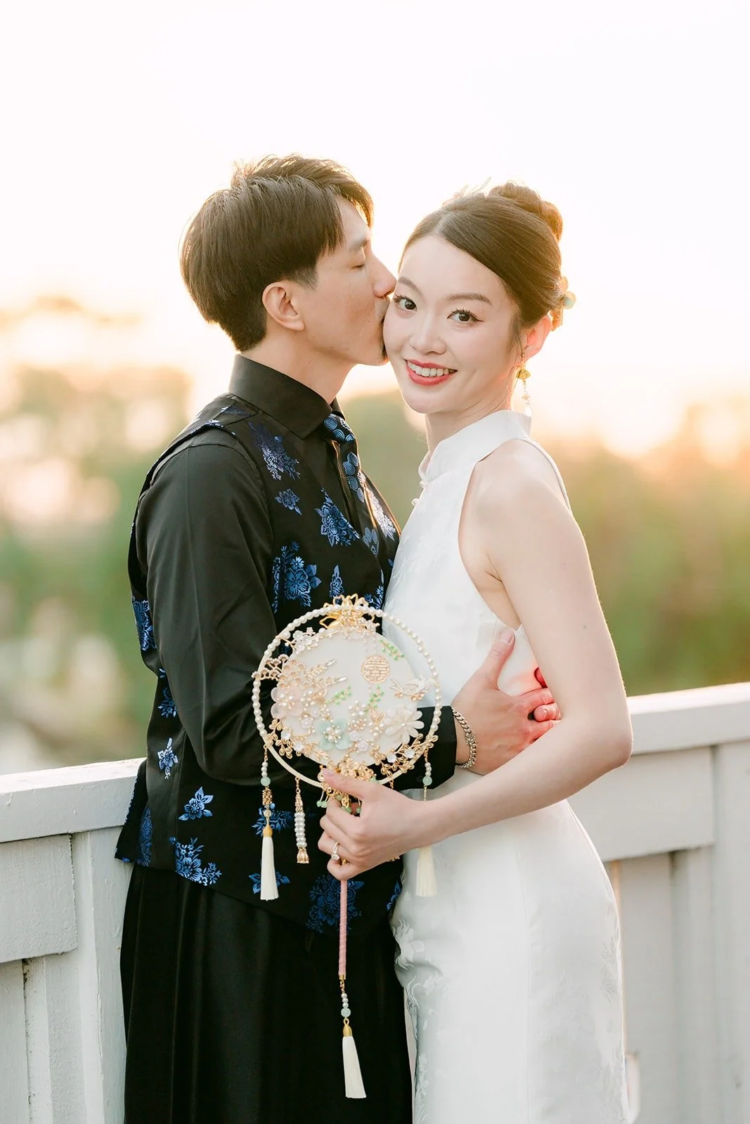Fong kissing Tin on the cheek at sunset