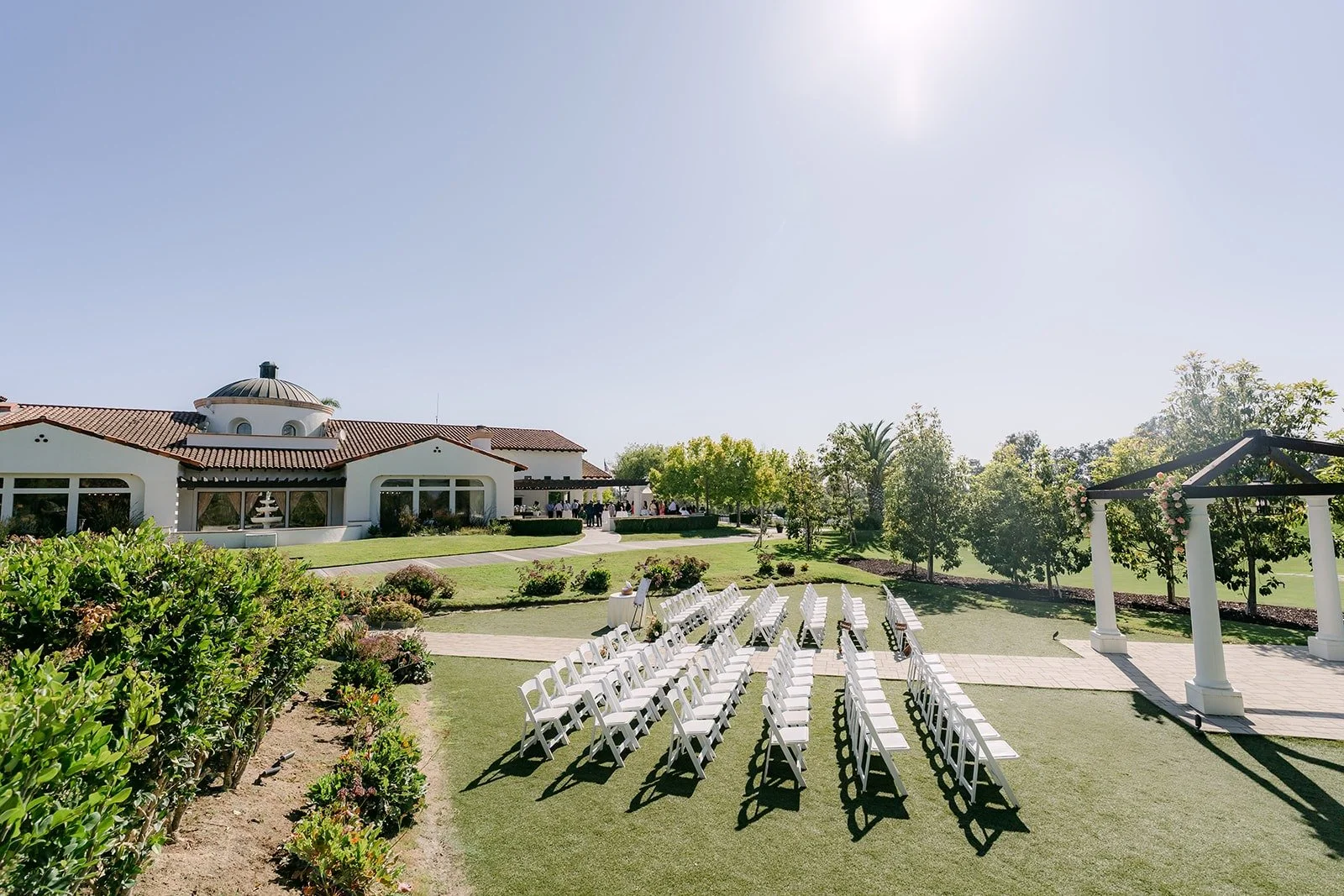 White ceremony chairs set on the lawn beside the clubhouse