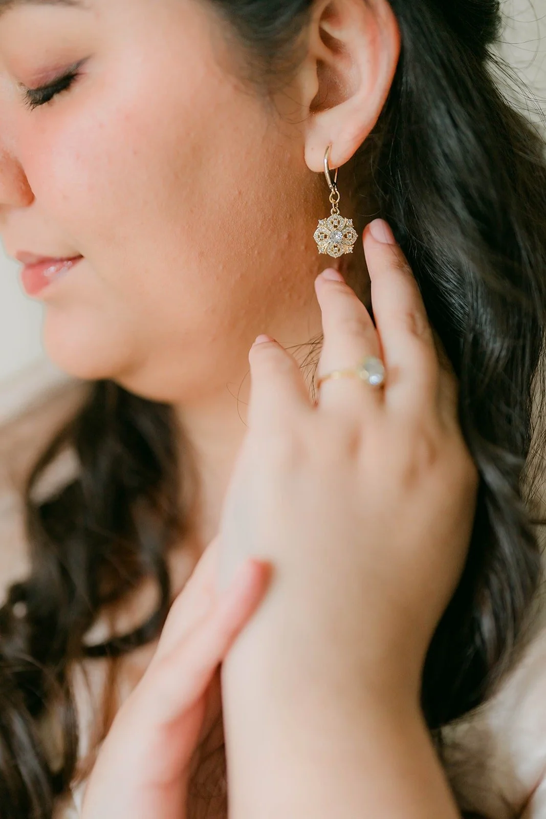 A close up of Saira's earring and engagement ring as she finishes getting ready