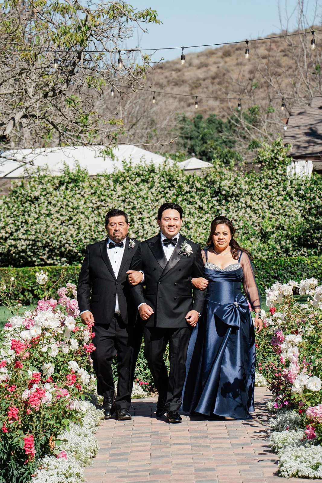 Groom walking down the aisle with his parents
