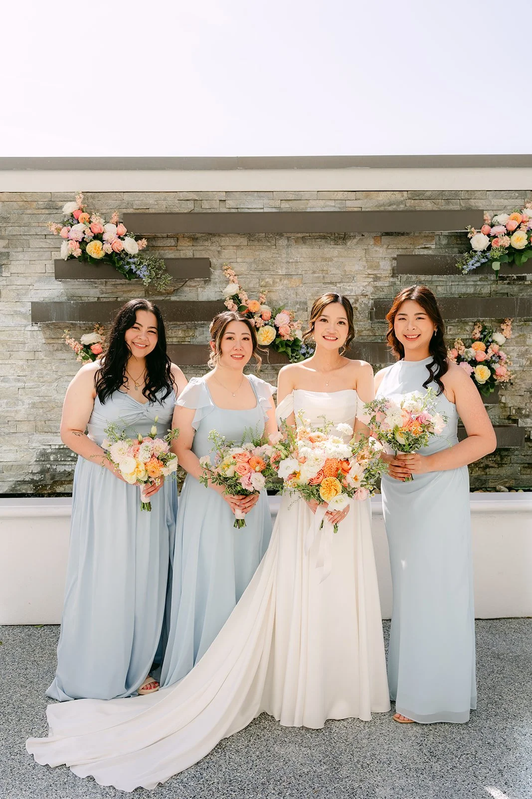 Amanda with her bridesmaids in light blue dresses on the terrace.