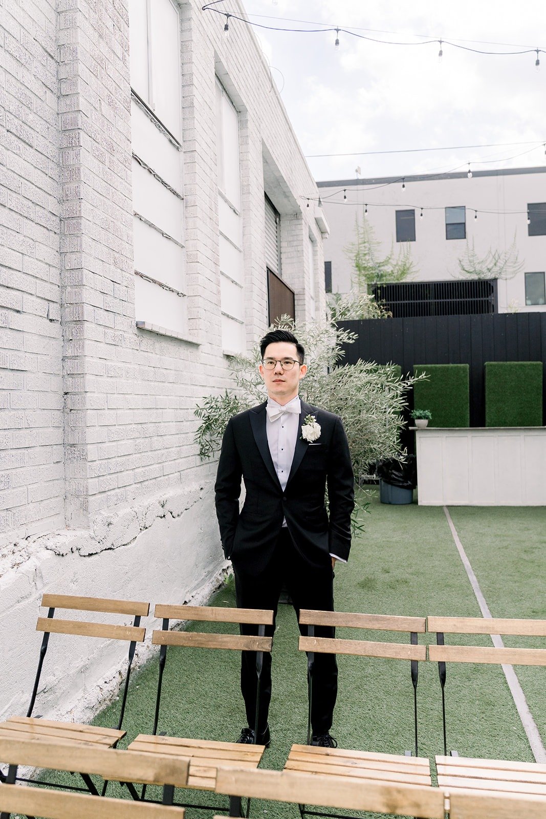 Alex waits on the turf courtyard at The East Angel for the first look