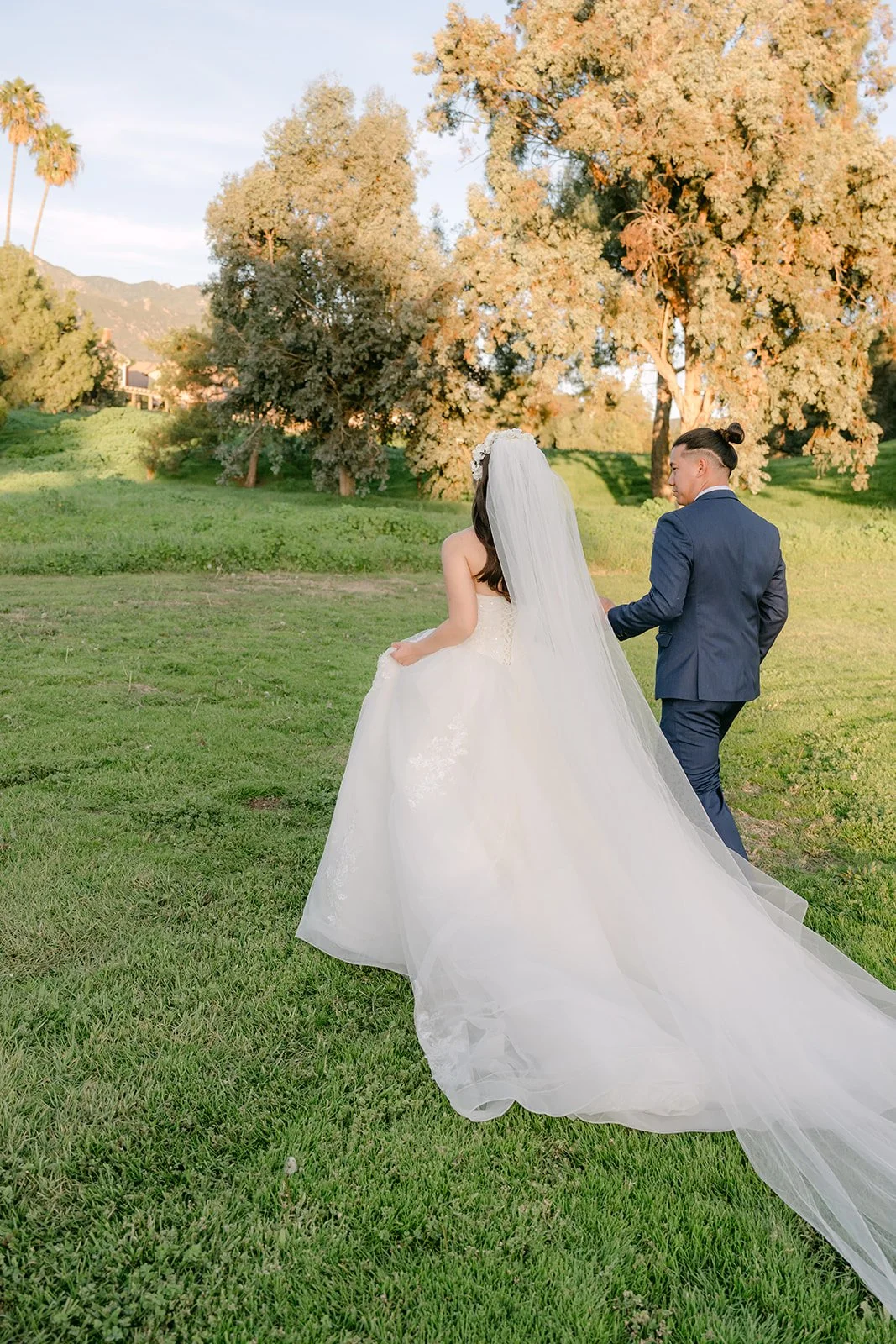 Kate and Michael walking across the golf course at sunset, photographed by One and Only Production.