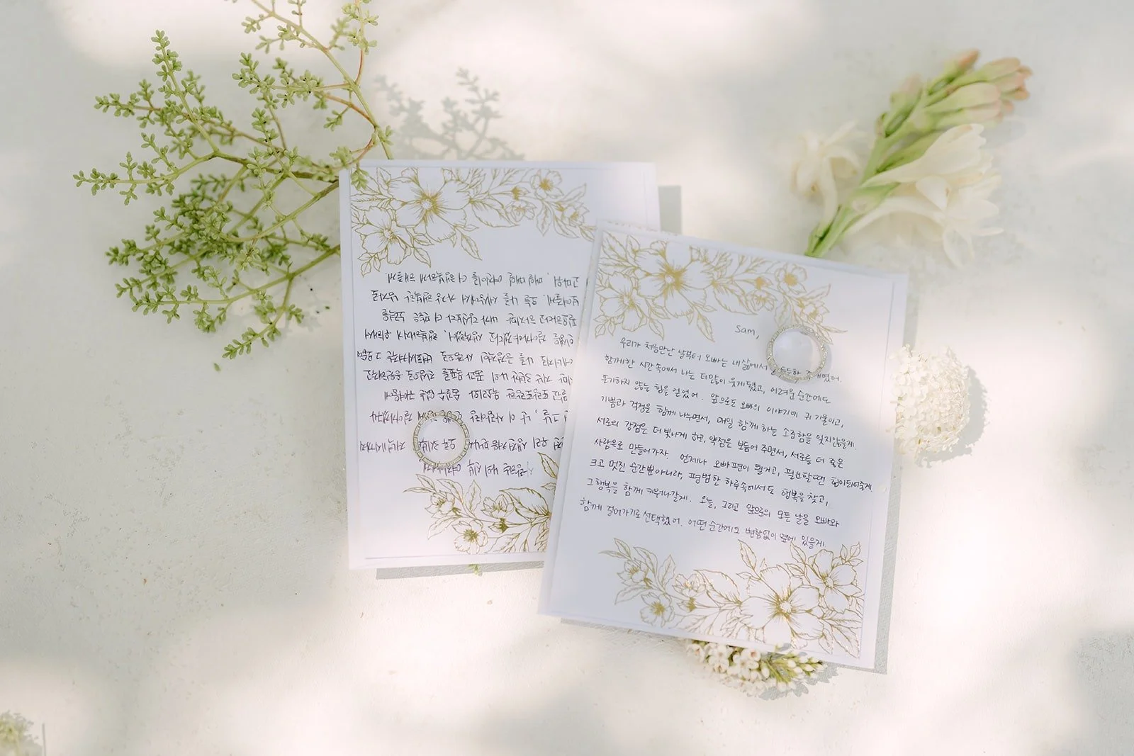 Handwritten vow card tucked into fresh greenery