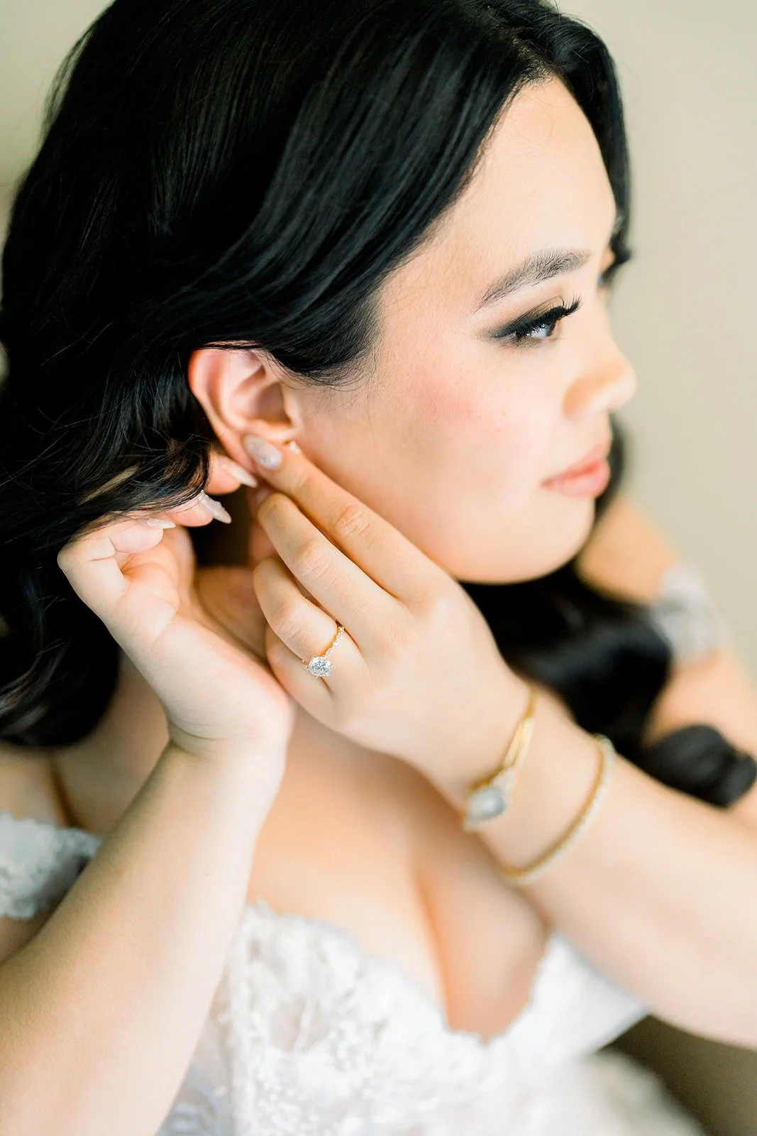 Close up of Francesca putting in her earring, her engagement ring catching the light