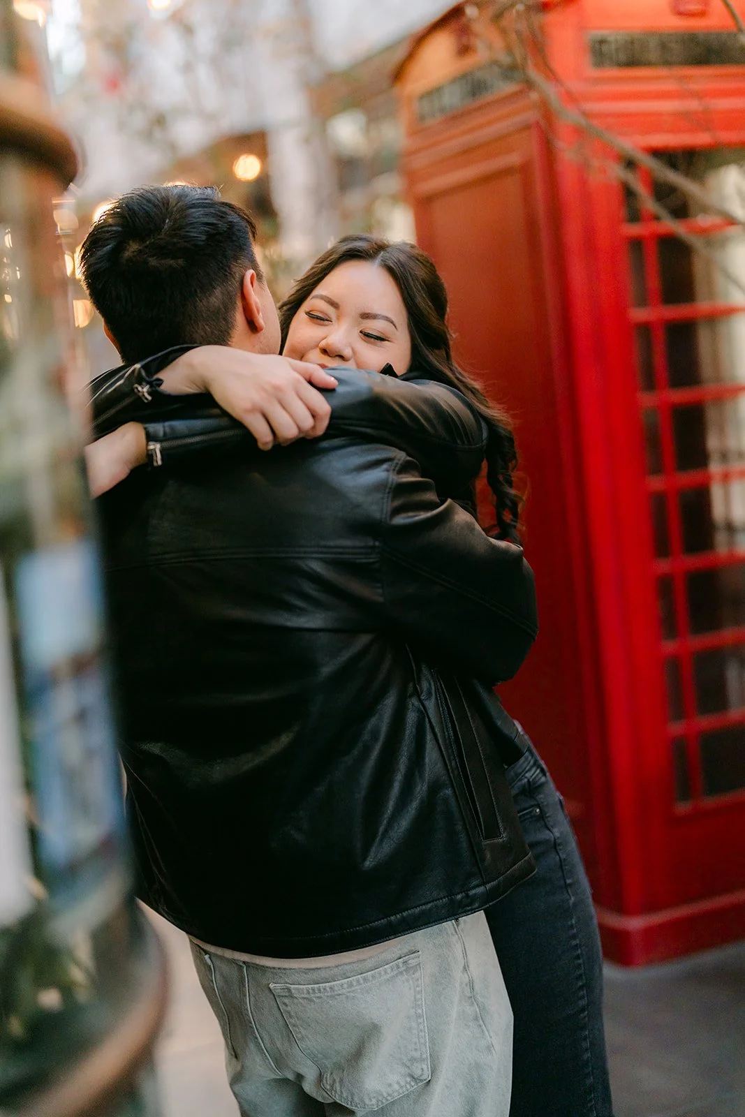James hugs Emily in front of the red phone booth.