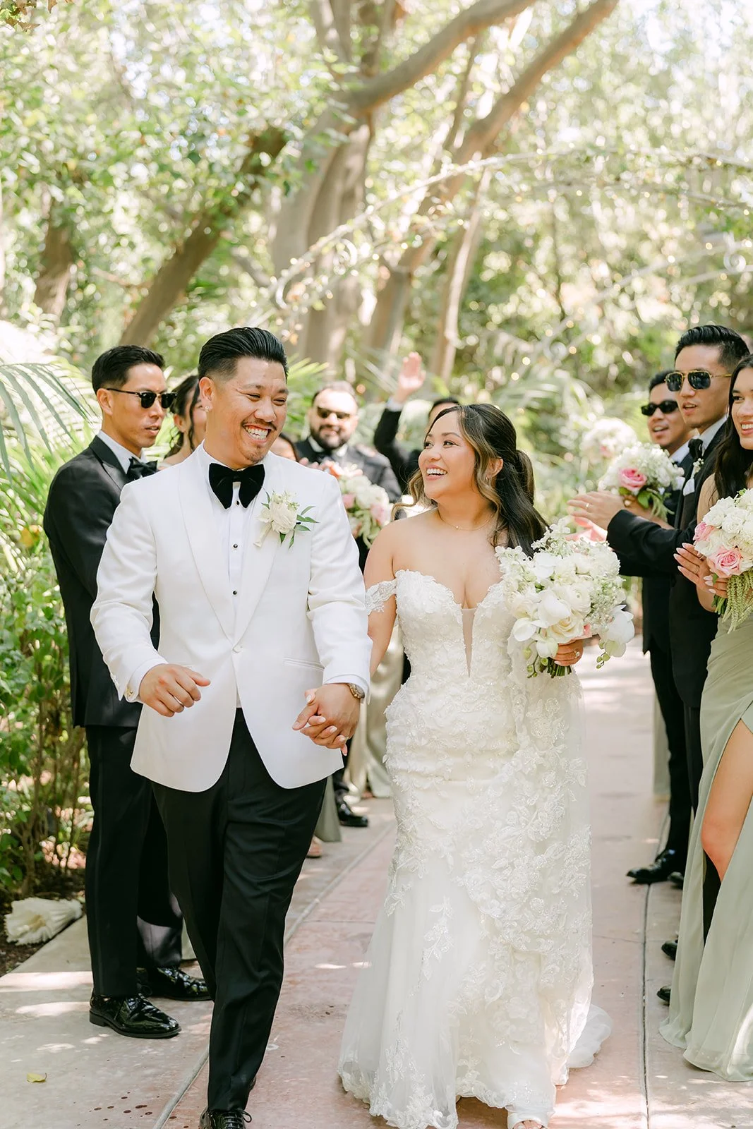 Caryl and Nicole laughing with their groomsmen and bridesmaids.
