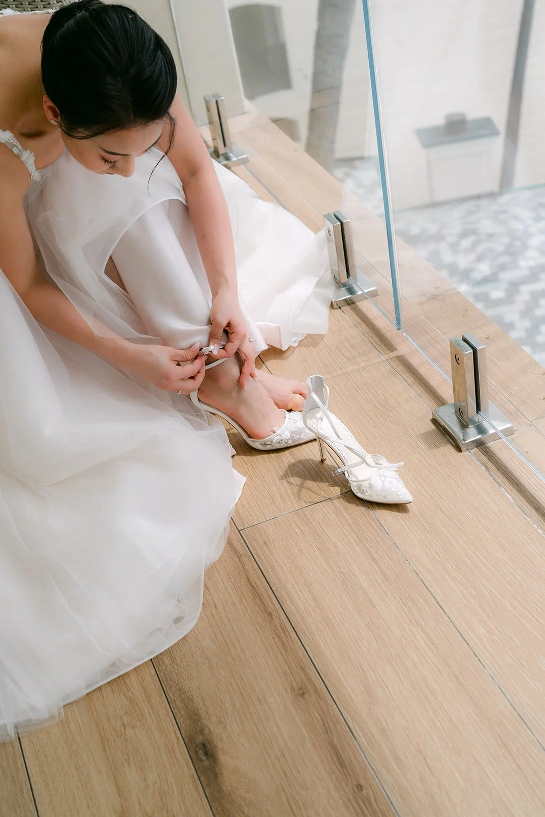 Kylie putting on her heels on the balcony floor