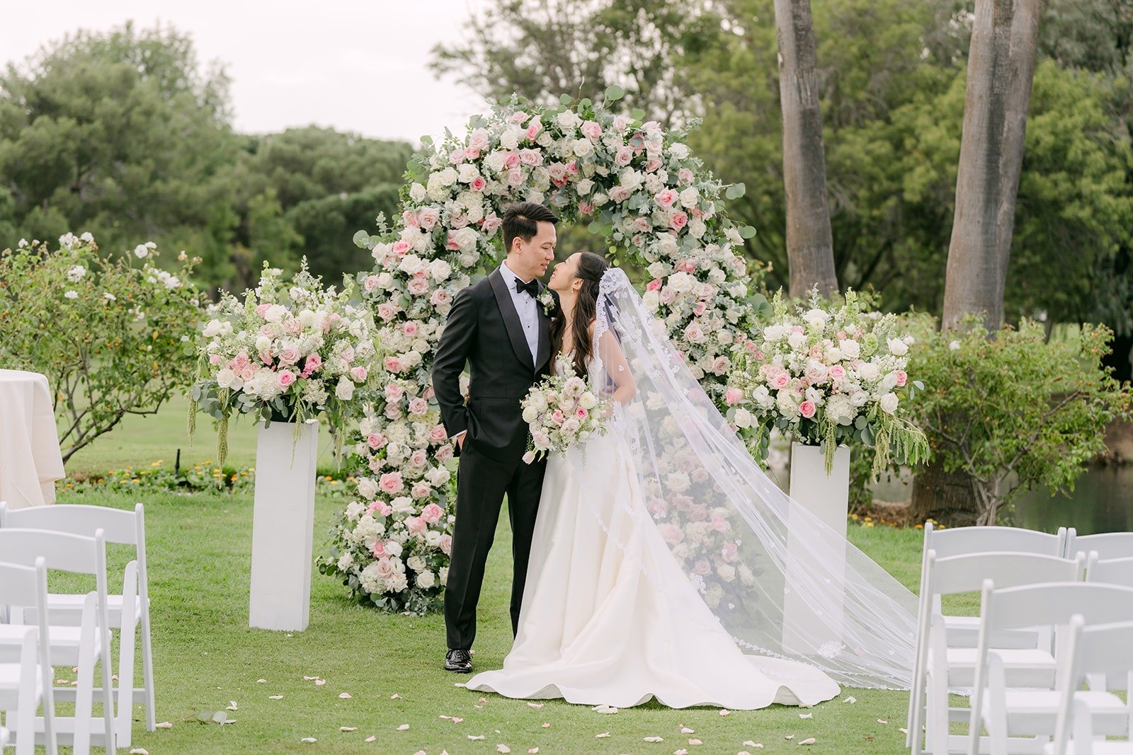 Kristine and William under the floral ceremony arch before the guests arrived
