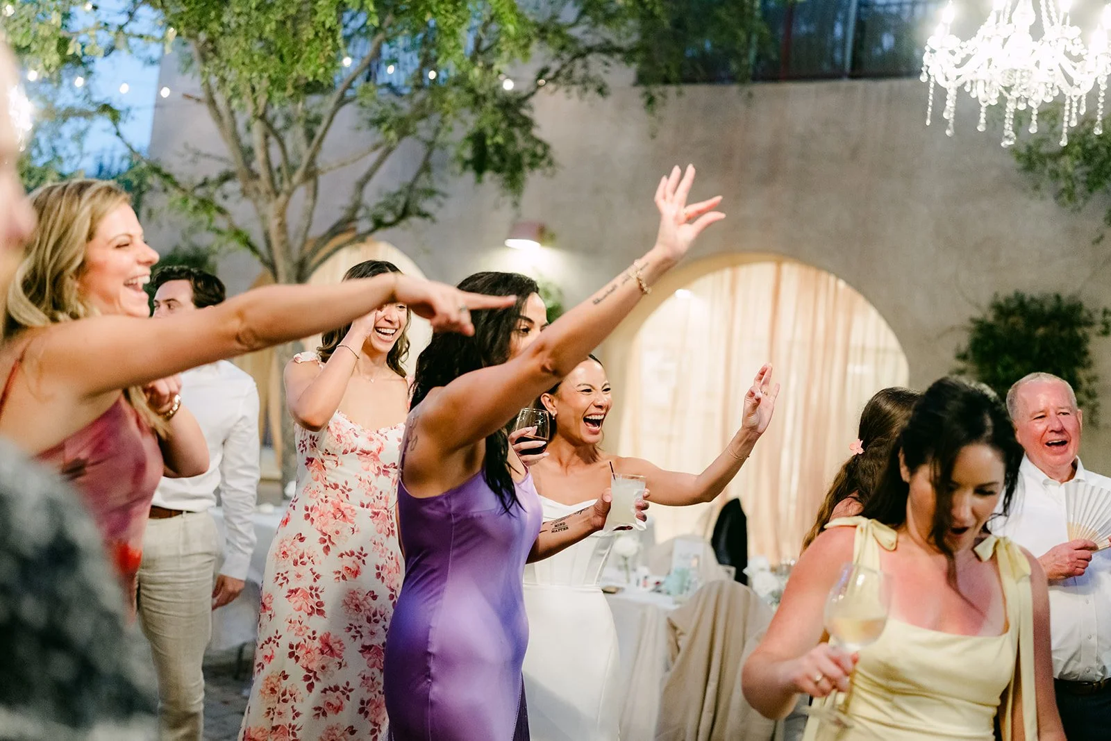Guests cheering with hands up on the dance floor, photographed by One and Only Production