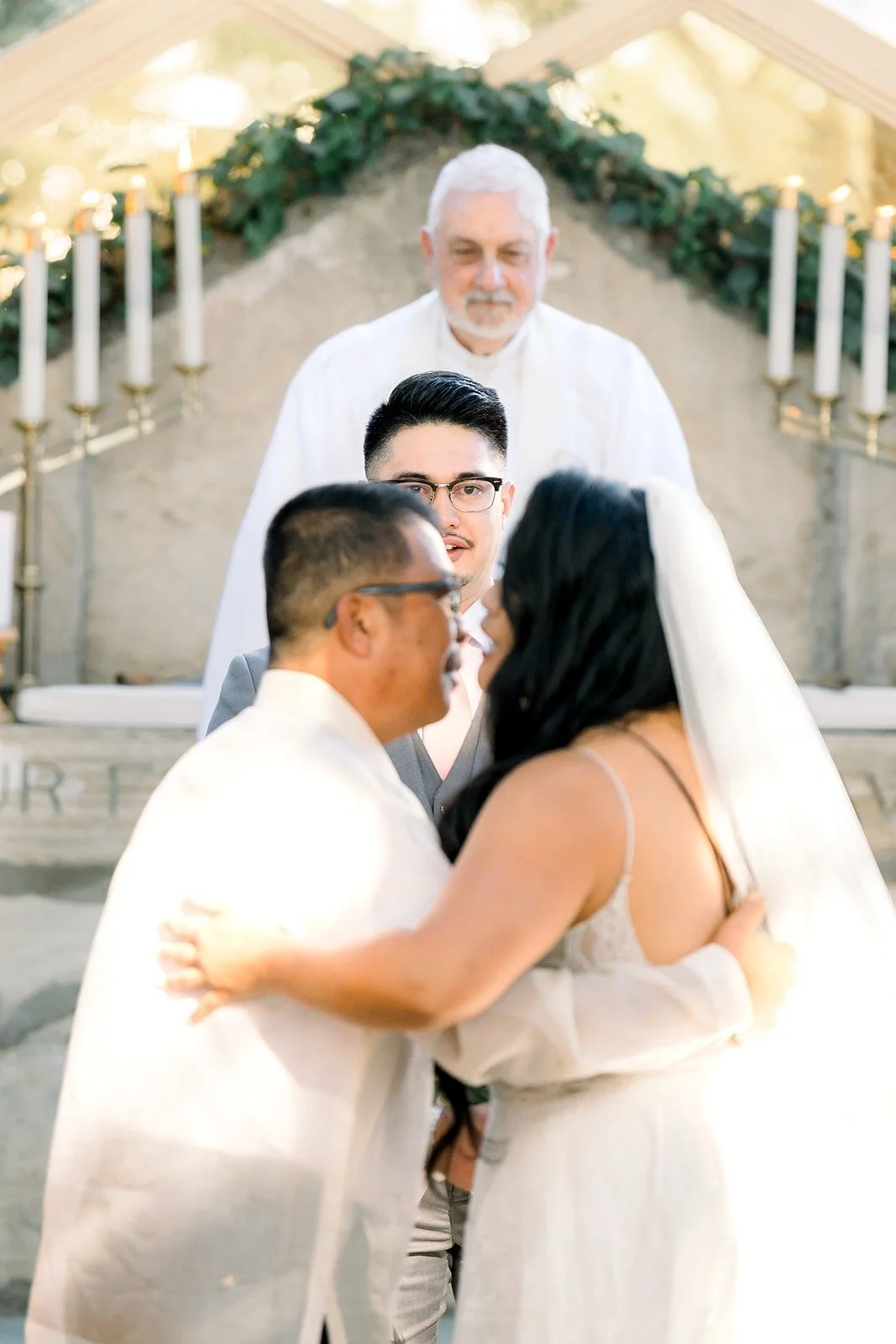 Betsy and a family member embrace at the front of the aisle