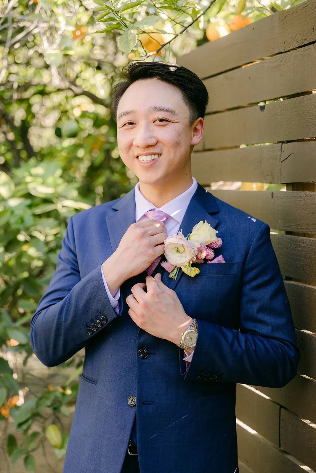 Elijah adjusting his boutonniere, photographed by One and Only Production.