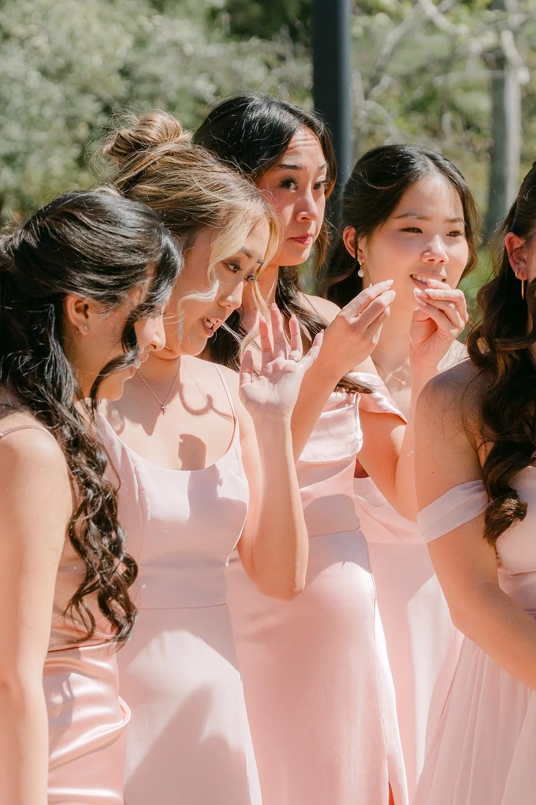 A bridesmaid wiping a happy tear after seeing Kelli in her gown