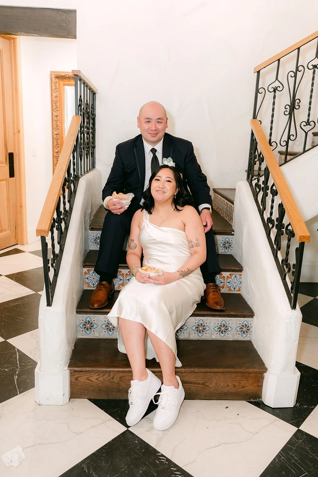 Vivian and Yao on the black and white staircase in their reception outfits, photographed by One and Only Production