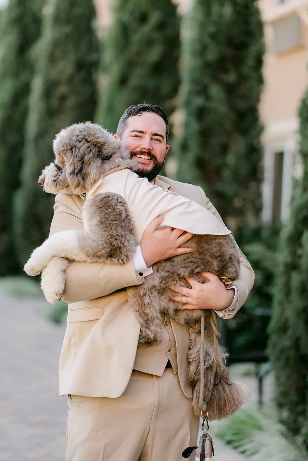 Cody holding Olive in his tan suit, photographed by One and Only Production.
