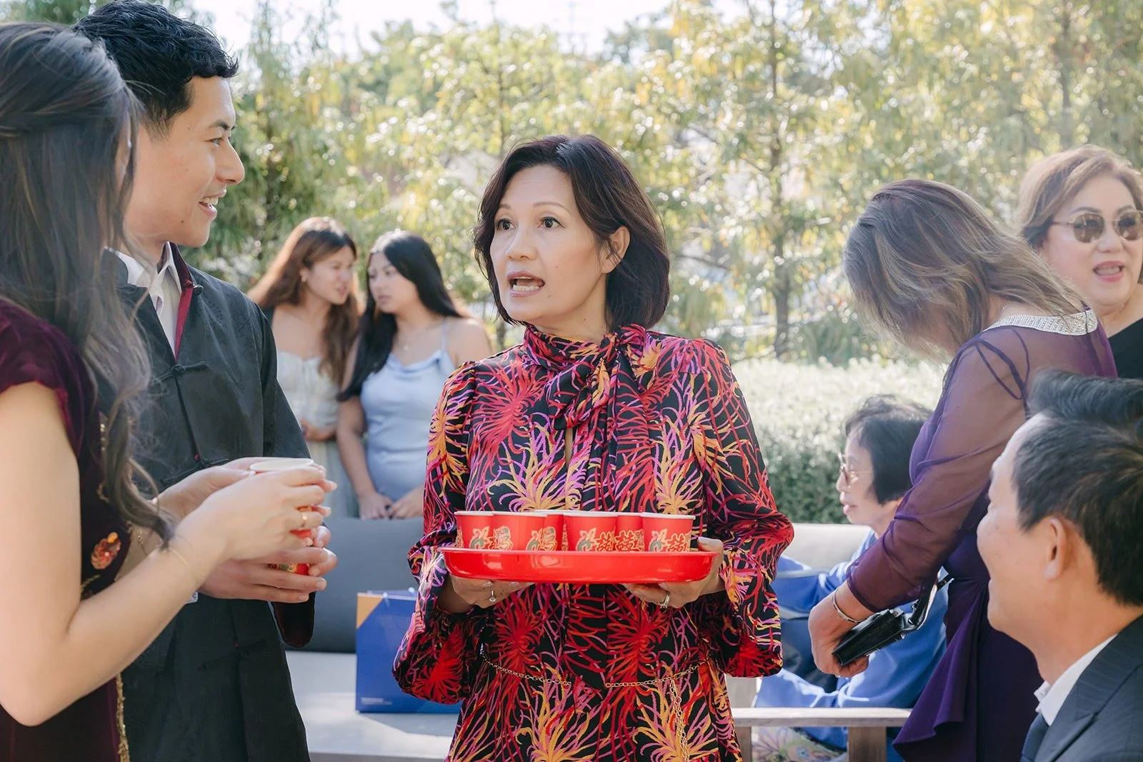 A family member holding a red tea tray during the tea ceremony