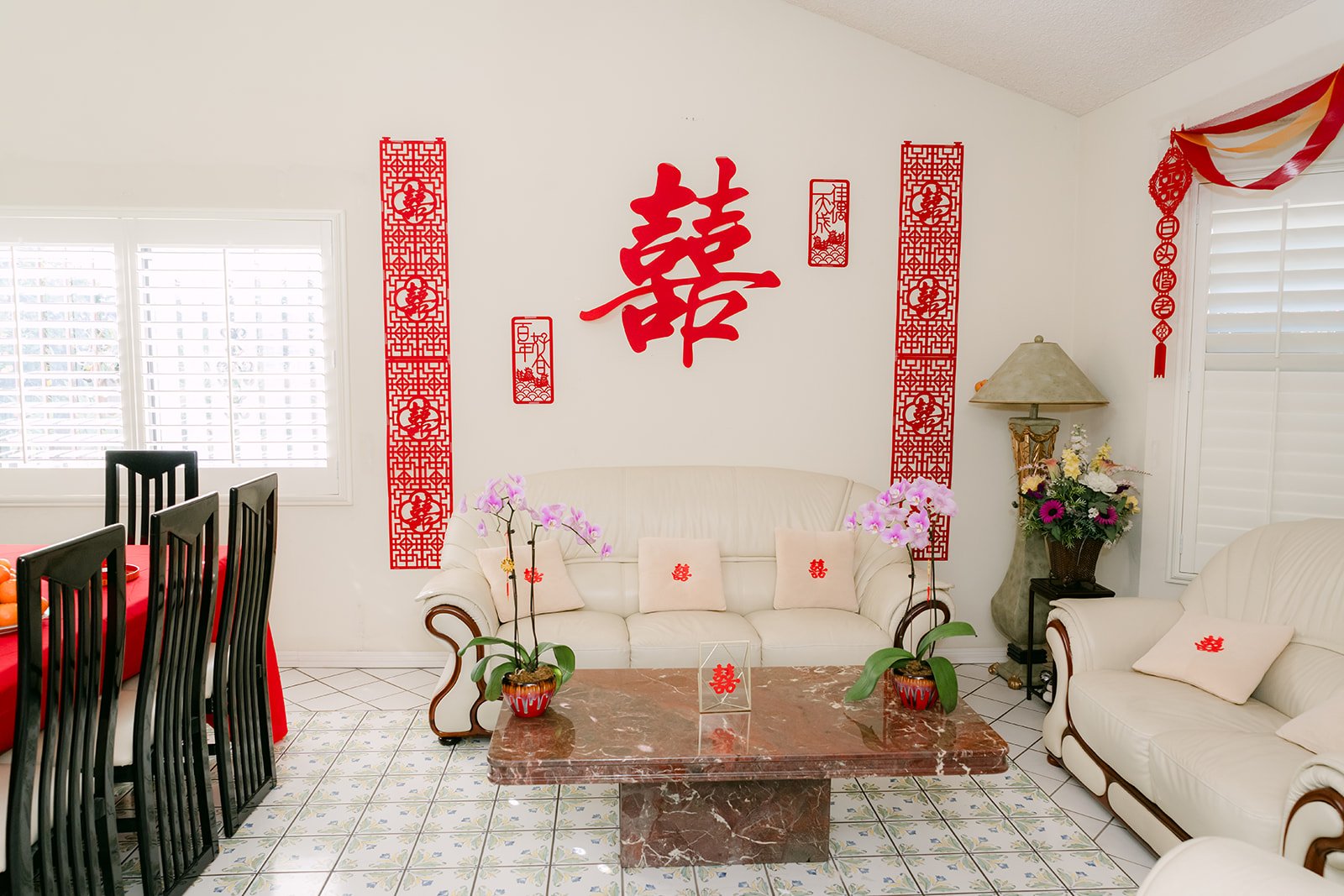 A living room decorated with double happiness papercuts and couplets for the tea ceremony.