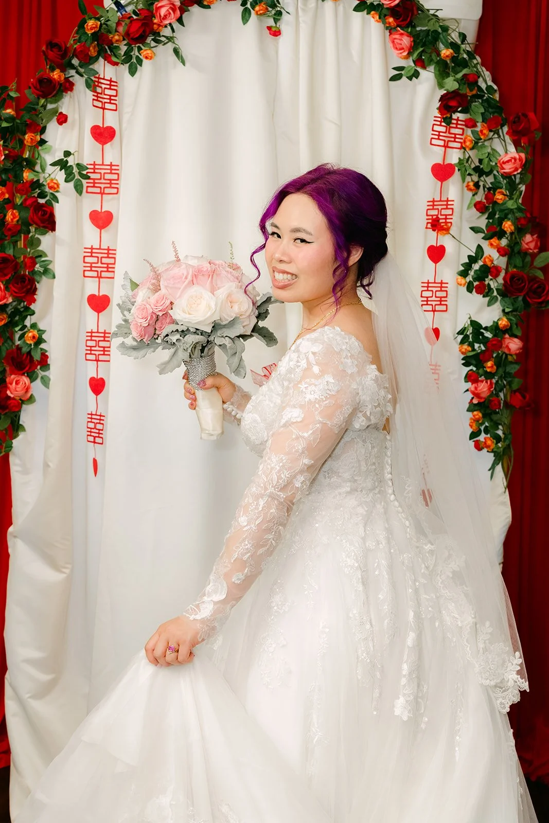 Vanessa smiling with her bouquet in her lace gown.