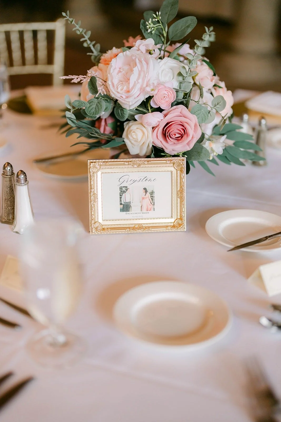 A blush rose centerpiece with a gold framed table card