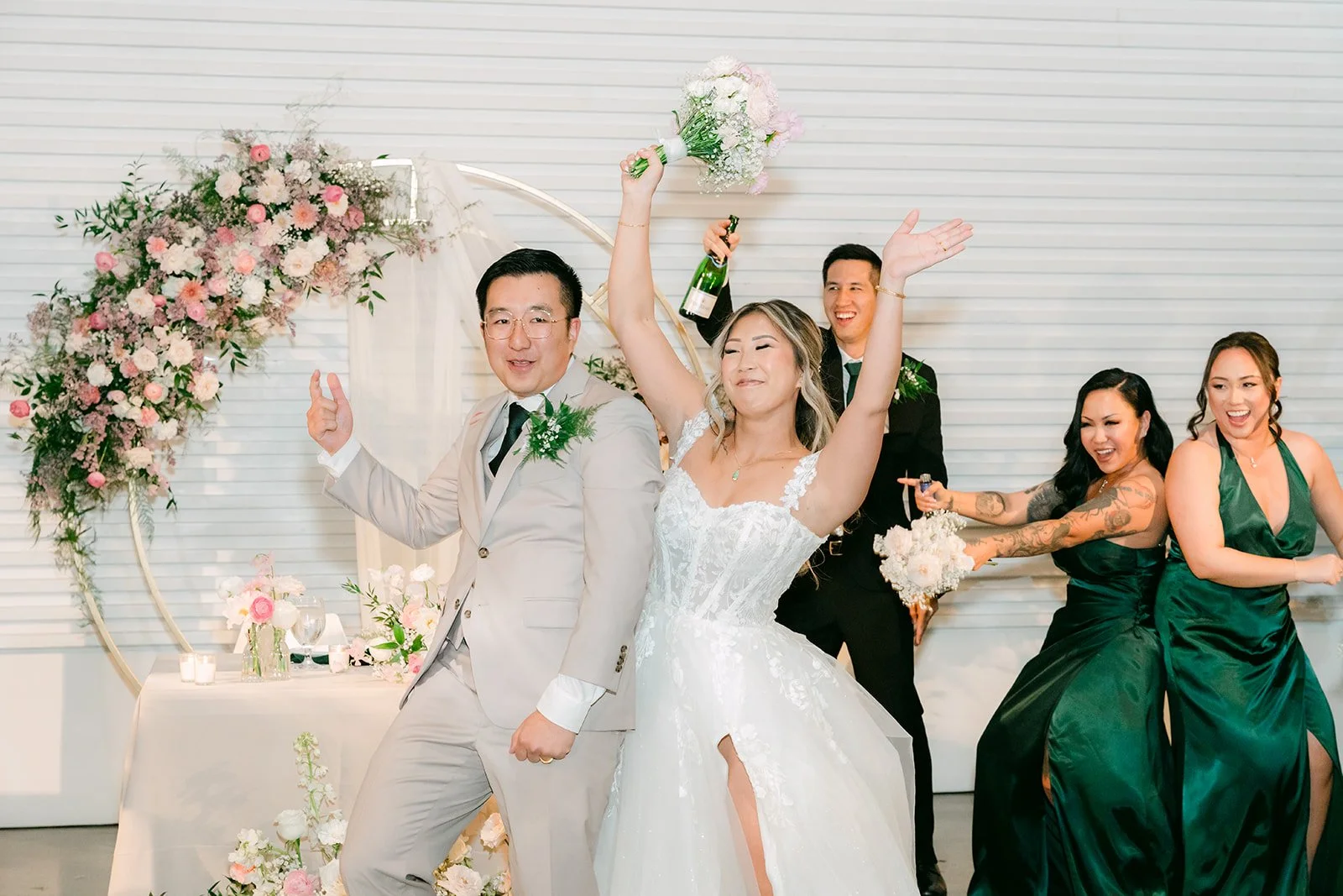 Couple dancing at the sweetheart table with bridesmaids cheering