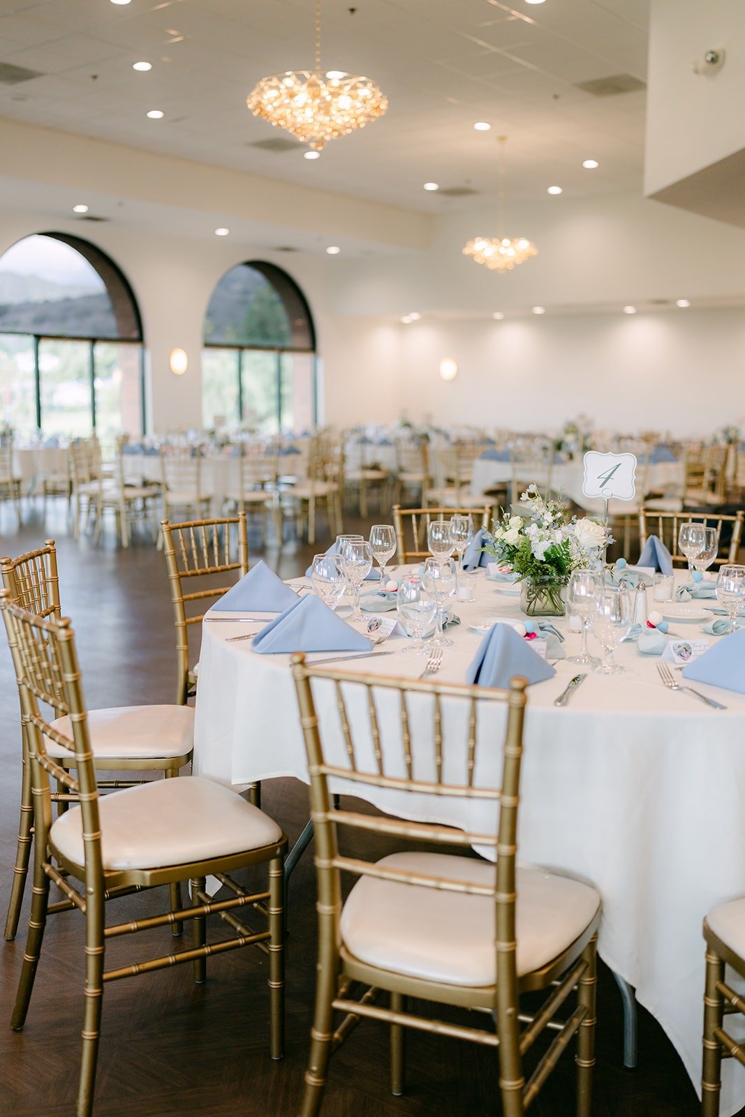 A table set with dusty blue napkins and white florals