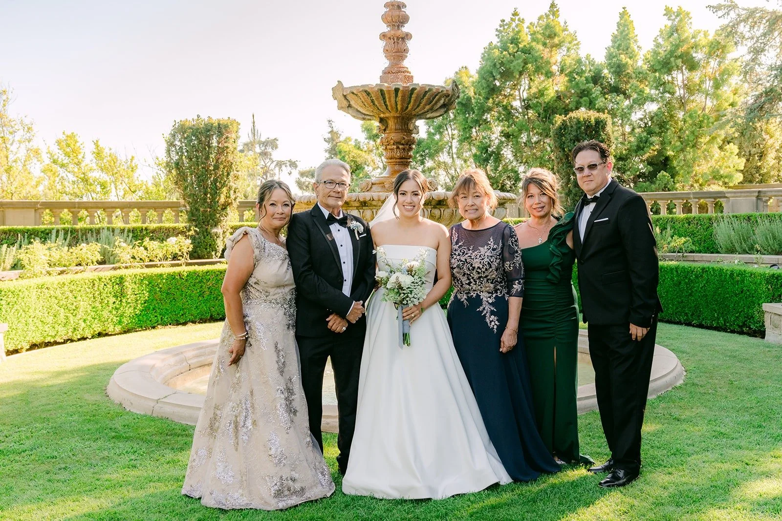 Brianna and Nik with family on the fountain lawn at Greystone Mansion