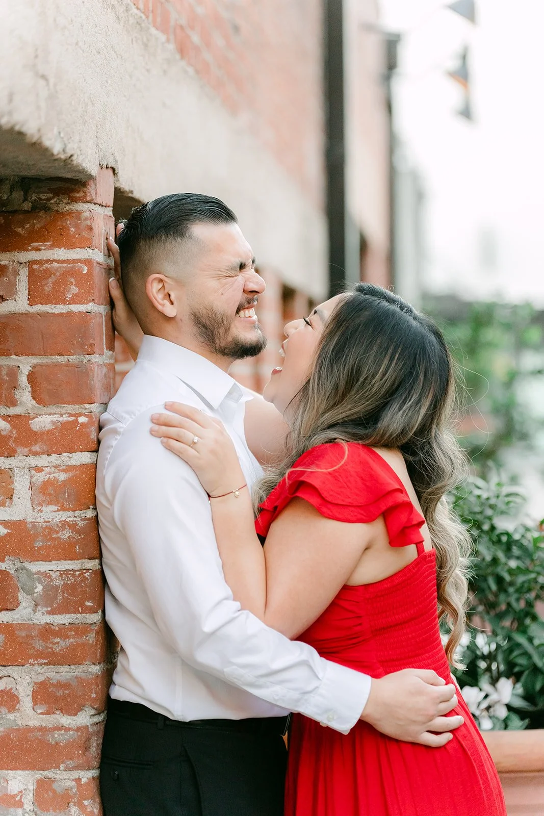 Linh and Ankush share a kiss against the brick wall.