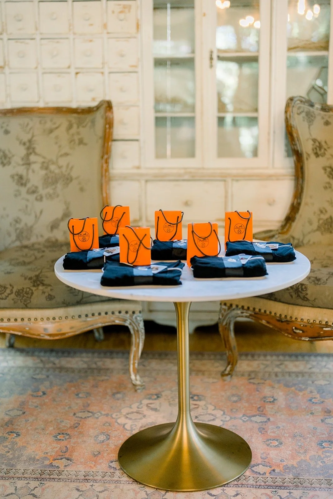 Orange gift bags waiting for the bridesmaids on a marble table at Twin Oaks House and Garden Estate, photographed by One and Only Production