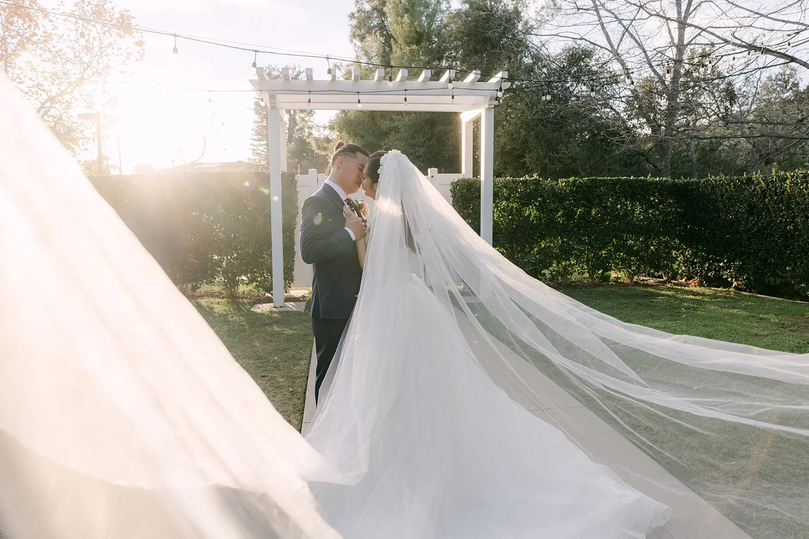 Michael with Kate's veil floating in front of the pergola.