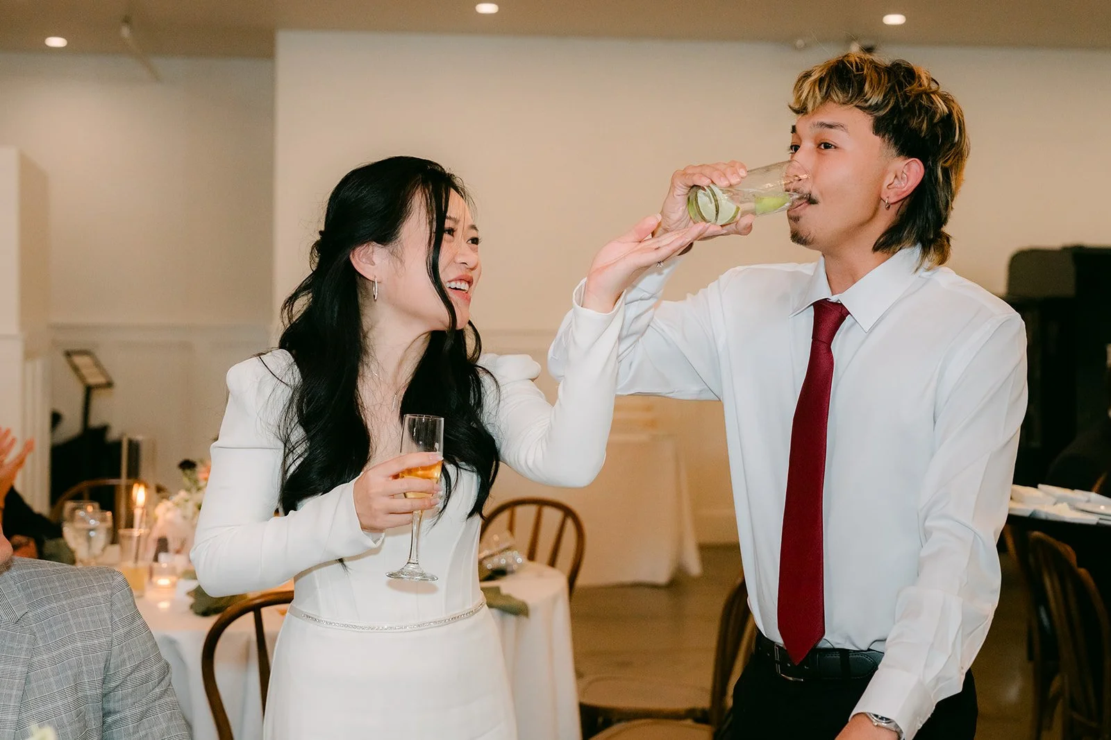 Denise taking a shot with a groomsman at the reception.