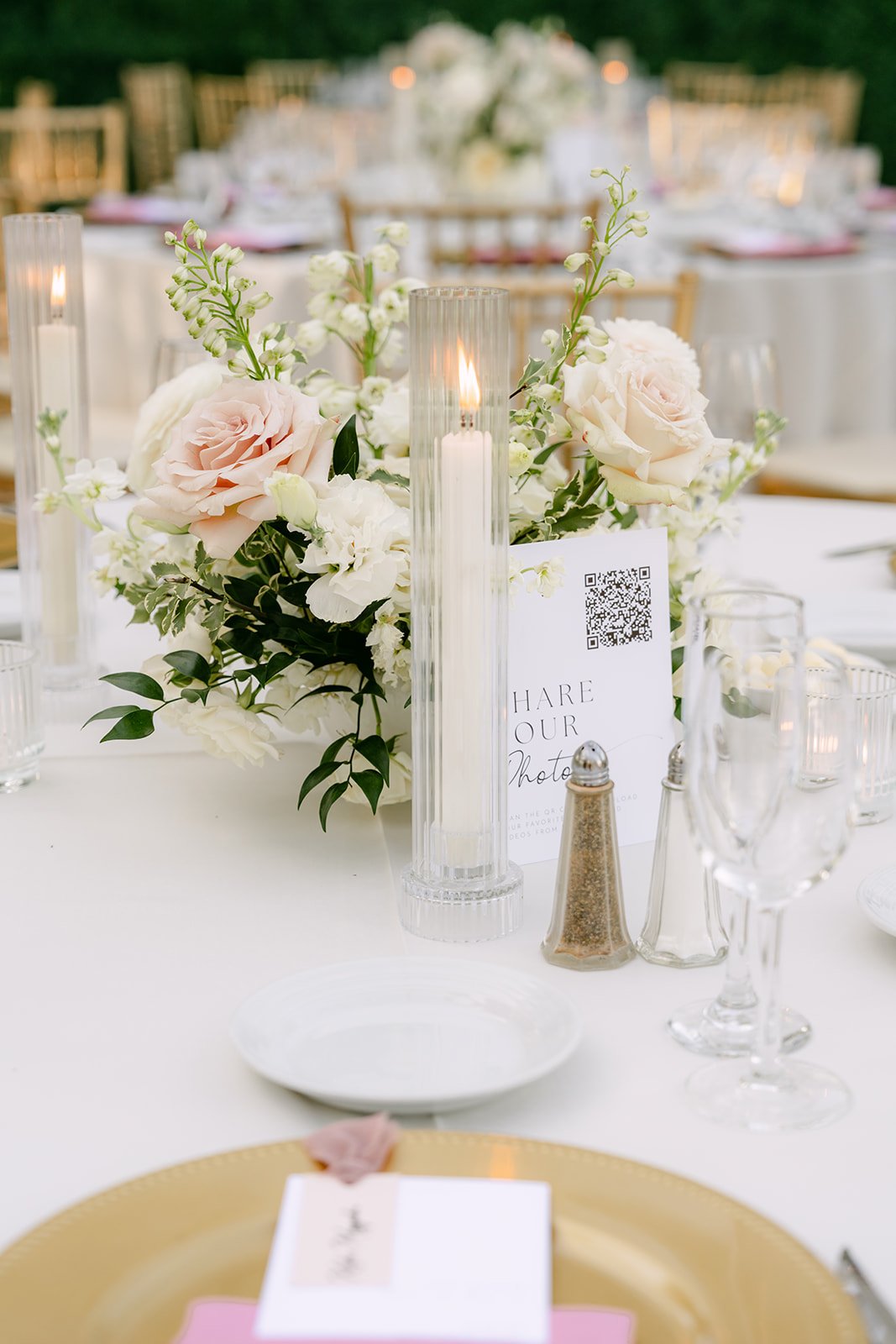 Blush florals and candles on a reception table.