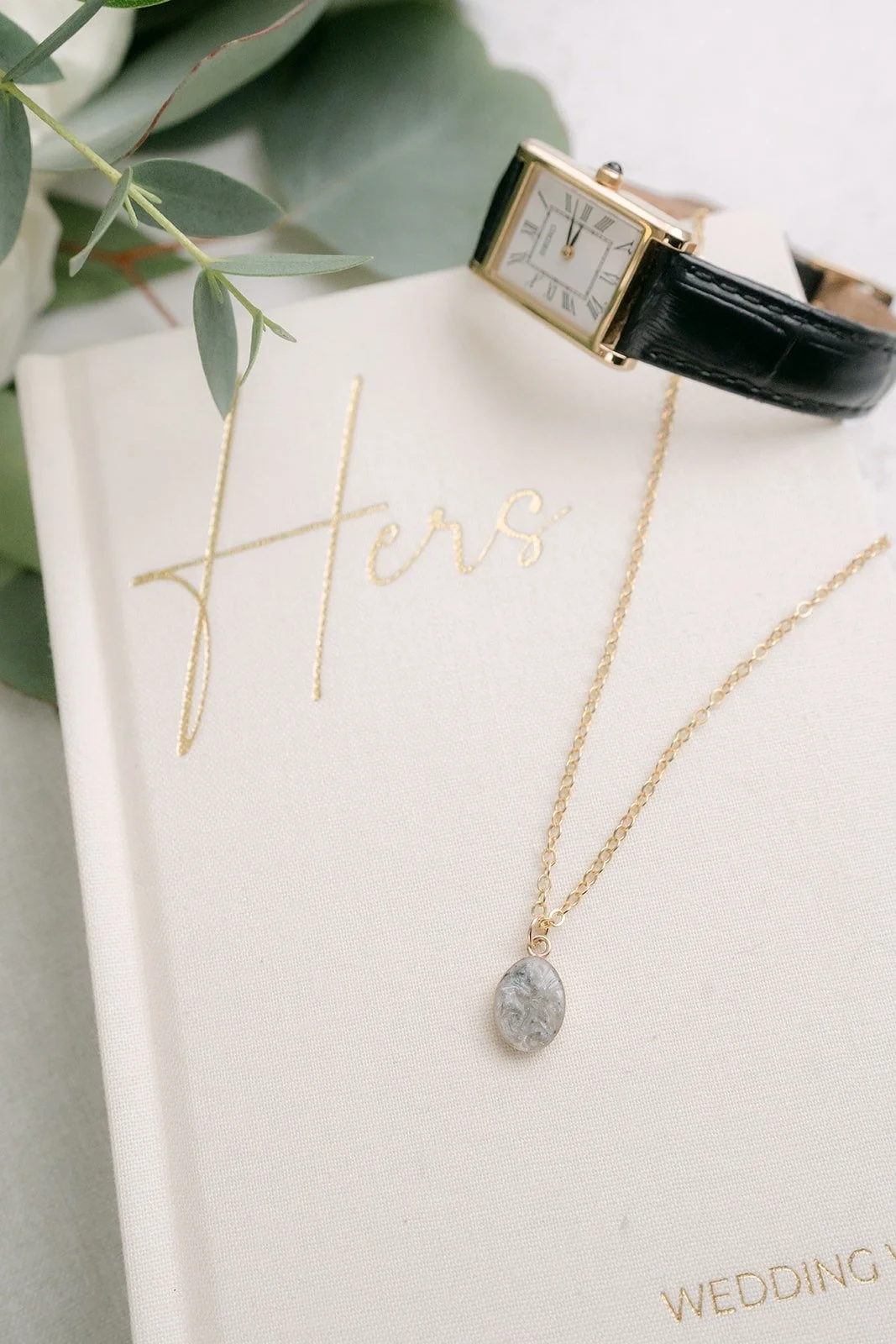 Vivian's necklace draped over her vow book