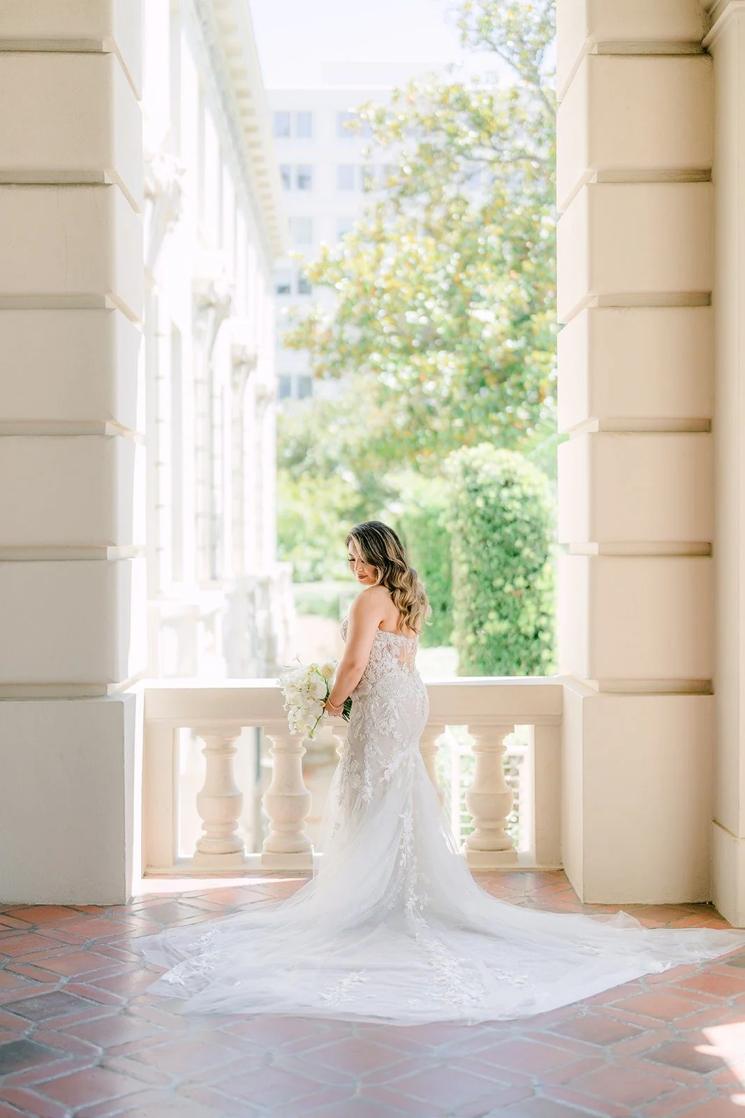 Candice in her lace gown between the arches at Pasadena City Hall