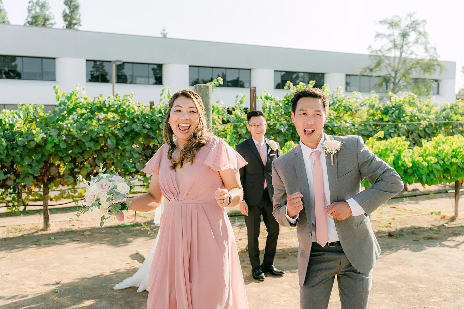 A bridesmaid and groomsman posing in the vineyard