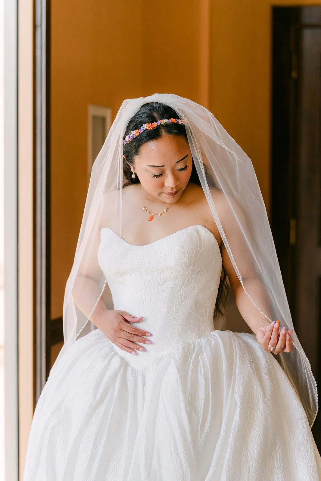 Angela adjusting her veil before the ceremony