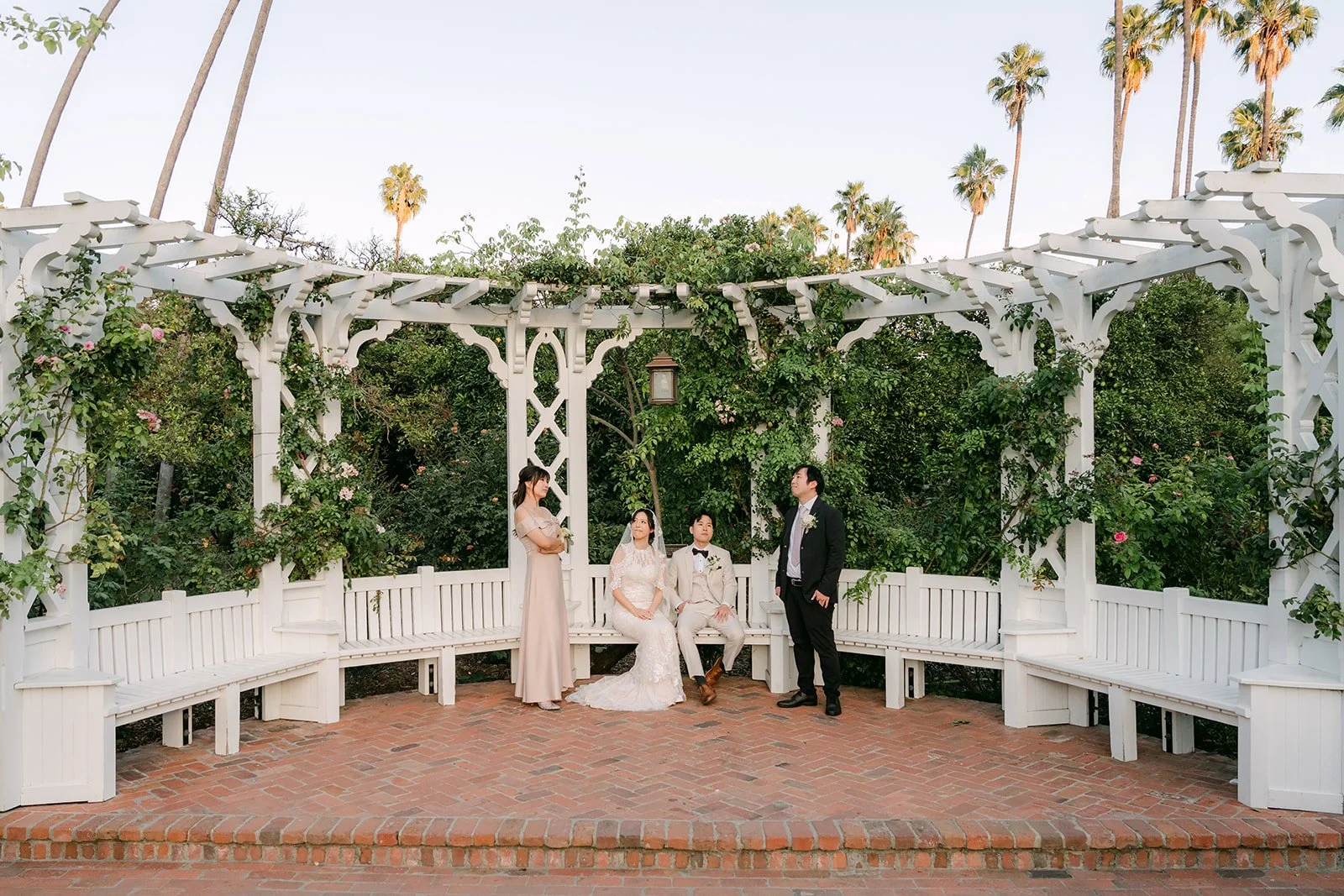 The wedding party at the white lattice pergola.