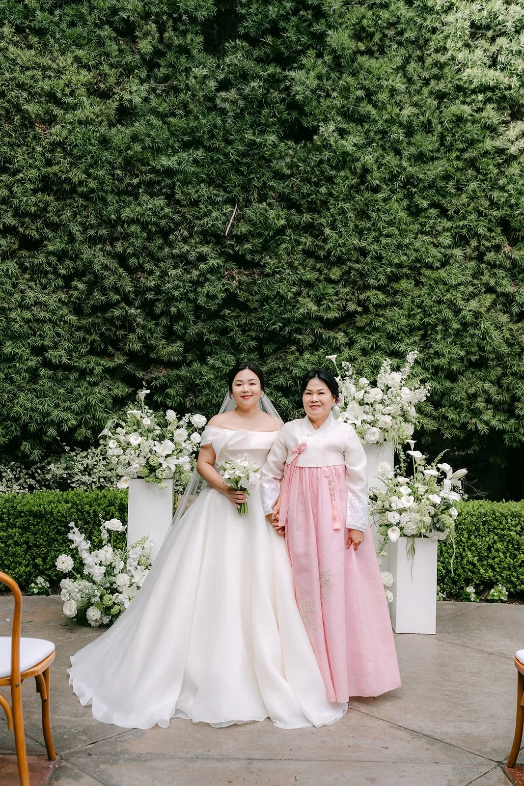 Chorok with a family member in pink hanbok in front of the ceremony florals