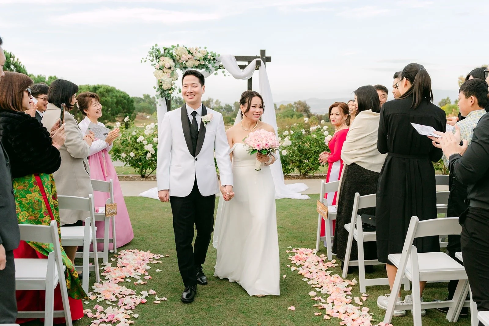 Ivy and Chungman walking back up the aisle as guests cheer