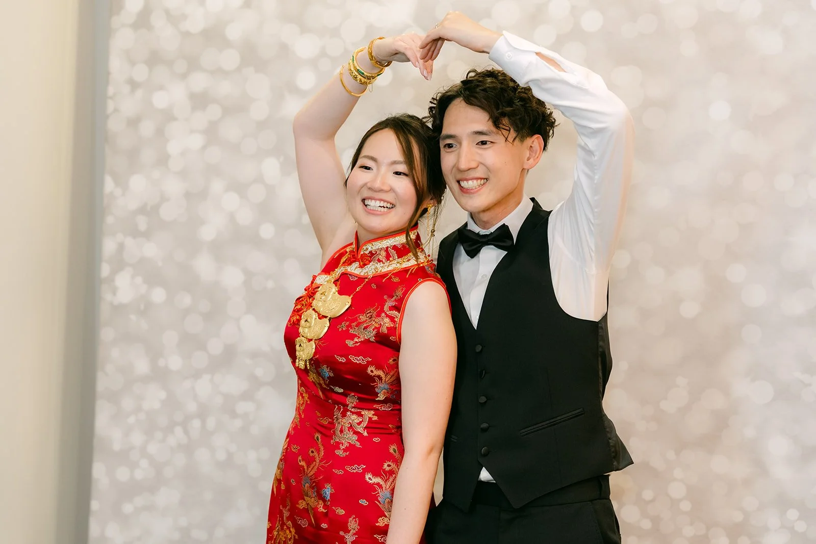 Victoria in her red qipao making a heart with Tony at the photo booth