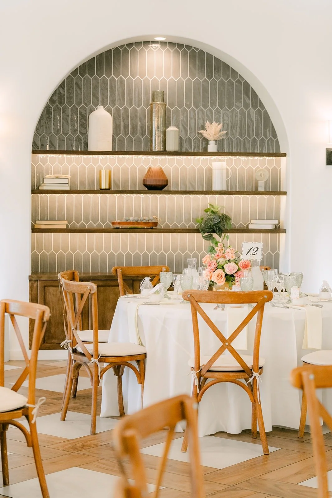 Reception tables in front of an arched shelf wall inside Sterling Hills