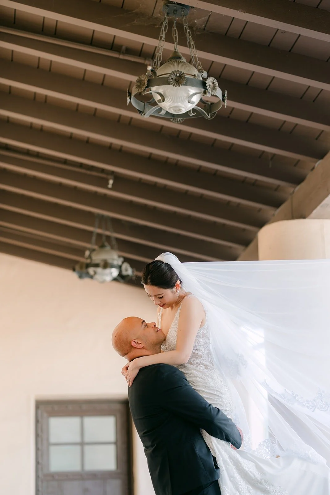Brandon dips Elisa as her veil floats behind her, photographed by One and Only Production